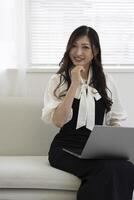 A working Japanese woman by remote work in the home office closeup photo