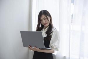 un trabajando japonés mujer por remoto trabajo en el hogar oficina de cerca foto