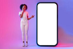 Woman pointing at giant white blank phone screen photo