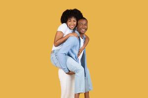 Playful African American couple enjoying a piggyback ride photo