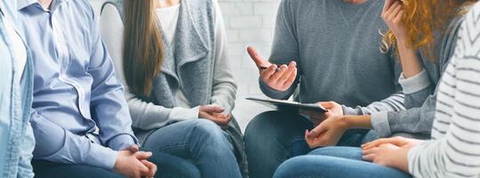 Therapist consulting patients of rehab group at therapy session photo