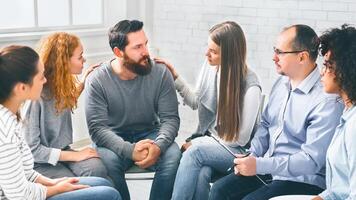 terapia grupo miembros consolador trastornado hombre en comunidad reunión en rehabilitación foto