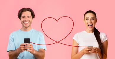 A man in a blue shirt happily using his smartphone and a woman in a white tee, with her hair in a ponytail photo