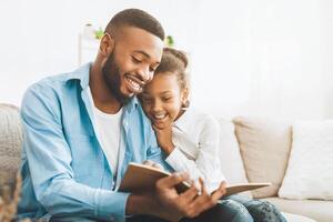 Loving daddy reading book to his happy daughter photo