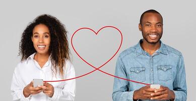 A radiant woman in a white shirt and a happy man in a denim shirt both hold smartphones photo