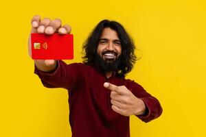 eastern guy pointing at credit card in his hand photo