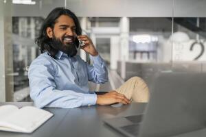 Man talking on phone with laptop at the office photo