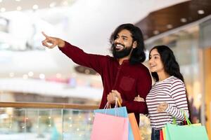 oriental hombre y mujer disfrutando temporada rebaja a compras centro comercial foto