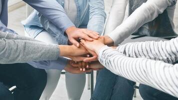 Happy rehab group patients connecting hands at therapy session photo
