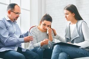 Understanding people calming crying woman during group session meeting in rehab photo