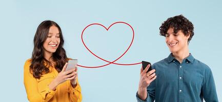 A man in a blue shirt and a woman in a mustard blouse are engaging with their smartphones photo