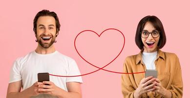 A joyful man in a white t-shirt and a woman in a tan jacket with glasses share a moment over smartphones photo