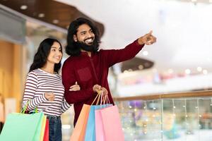 Loving young indian couple shopping together at city center photo
