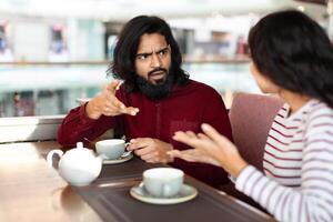 emocional joven indio Pareja tener lucha a café foto