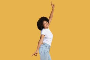 Joyful African American woman dancing and pointing upwards with a radiant smile photo