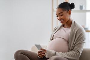 positivo joven negro embarazada mujer utilizando célula teléfono foto