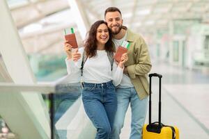 contento joven Pareja en aeropuerto participación pasaportes y embarque pasa foto