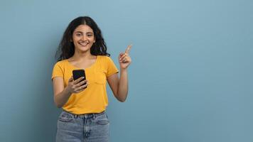 Smiling woman with phone making gesture photo