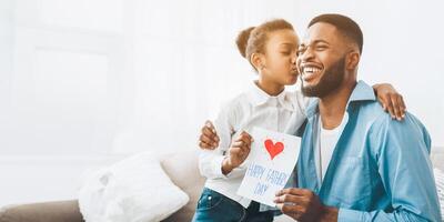Happy daughter kissing dad and giving greeting card photo