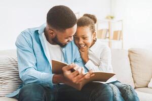 Cute girl and loving father enjoying time together, reading book photo