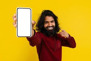 Cool indian man pointing at phone in his hand photo