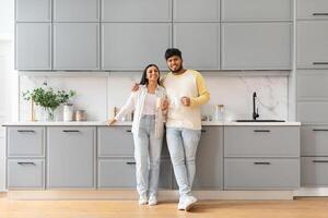 Beautiful loving indian couple enjoying morning coffee at kitchen photo