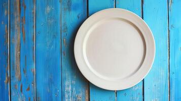 AI generated white empty plate on blue wooden table  top view photo