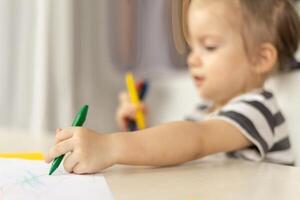 Adorable caucasian baby girl drawing greeting card for mothers day. Image with selective focus on hand photo