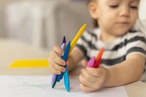 Cute caucasian baby girl drawing greeting card for mothers day. Image with selective focus on hand photo