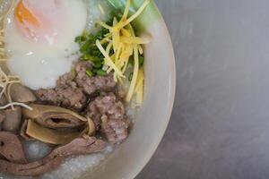 Congee with minced pork, liver, pork entrails and boiled egg in a bowl photo