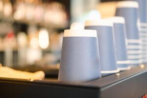 Stack of blue paper cups lies on the rack in a row photo