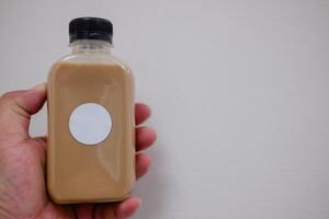 Iced latte in a bottle with an empty label ready for logo design. photo