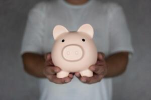 Business finance and saving money investment concept. Man holding pink piggy bank. photo