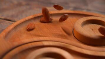 Almendras en un de madera cuenco en un oscuro rústico de madera antecedentes video