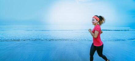 Woman jogging workout on the beach in the morning. Relax with the sea walk. in summer photo