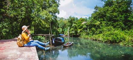 Asian woman travel nature. Travel relax.a boat photo. Sitting watching the beautiful nature at tha pom-klong-song-nam. Krabi, in Thailand. photo