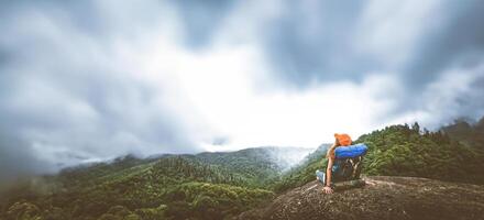 Asian women travel relax in the holiday. Sit on a rocky cliff. Mountain View Thailand photo