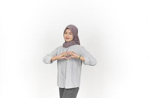 Young Asian woman wearing hijab showing love heart sign isolated on white background photo