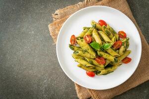 penne pasta with pesto sauce and tomatoes photo