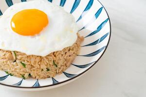 arroz frito con cerdo y huevo frito al estilo japonés foto