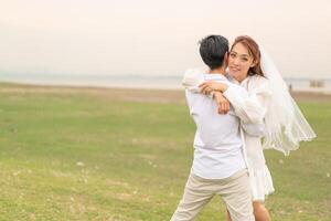 Happy young Asian couple in bride and groom clothing photo