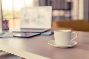 taza de café con leche en la mesa de trabajo foto