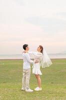 Happy young Asian couple in bride and groom clothing photo