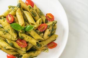 penne pasta with pesto sauce and tomatoes photo