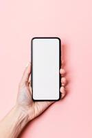 AI generated Hand Holding a Smartphone With a Blank Screen Against a Pastel Pink Background photo