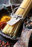 AI generated Bundle of Dried Spaghetti Tied With String on a Rustic Wooden Surface Amidst Spices photo