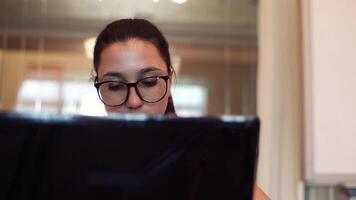 Young beautiful business woman working using mobile computer sitting at table in office. Close-up. video