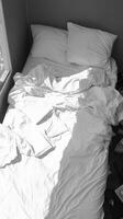 AI generated Monochromatic comfort White bedding in disarray, black and white tones Vertical Mobile Wallpaper photo