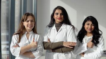 Medical students interns of different nationalities look into the camera and show a sign of approx. Doctors team video