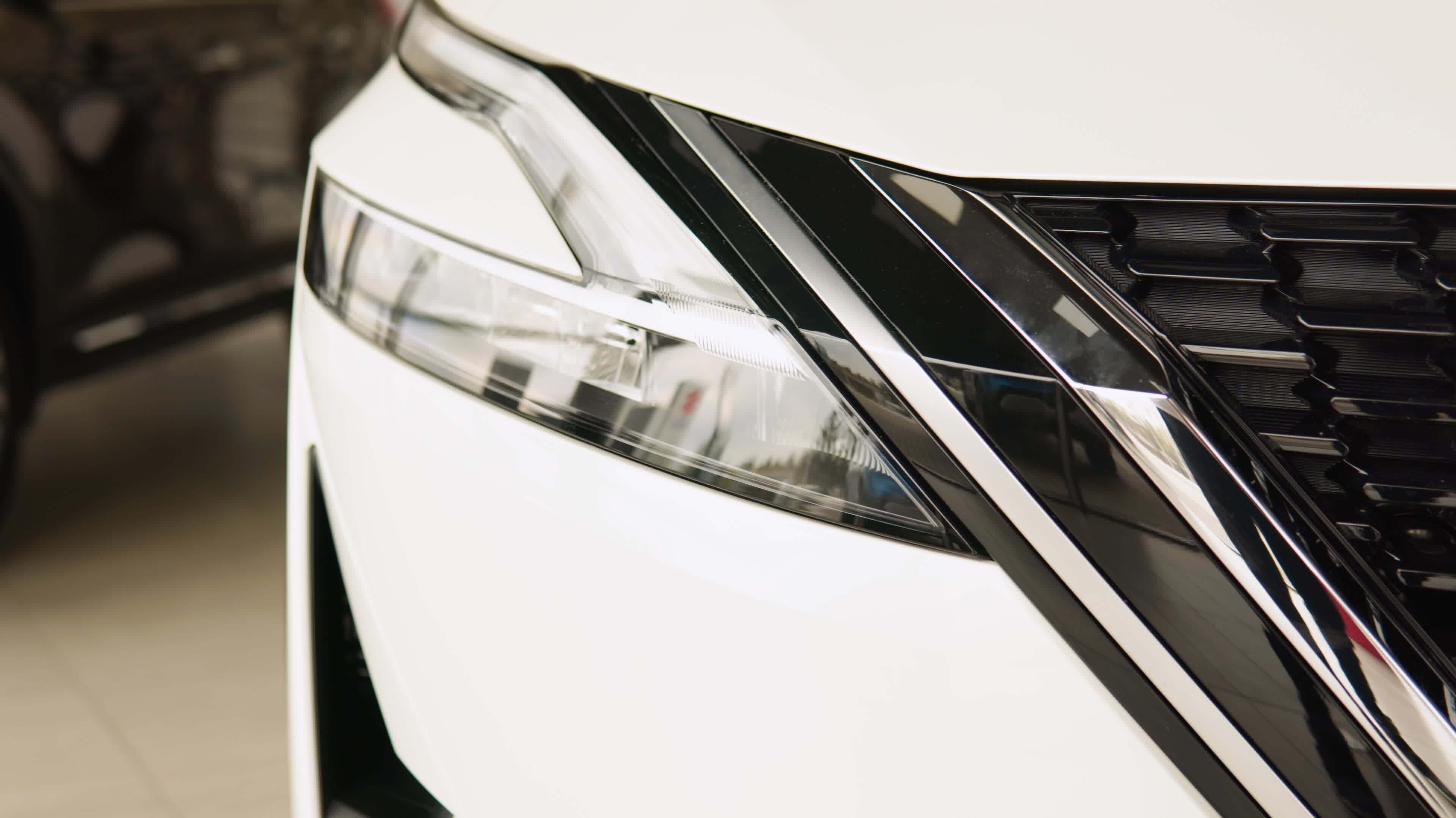 Close up of details of headlights of anonymous prestigious white luxury modern car. Shot in 4K ...